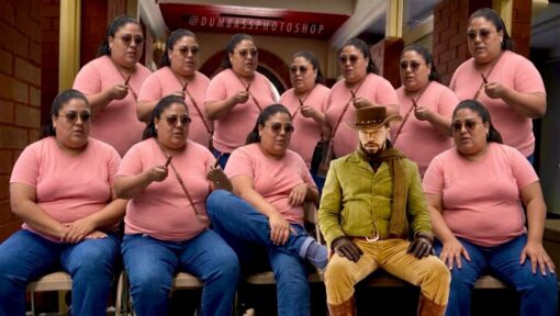 Cowboy Memes, Funniest Memes, Mashup Memes, Movie Memes, Photography Memes, Photos Gone Wrong, Pics Gone Wrong, Weird Memes, WTF Memes, A heavily edited group photo shows the same woman duplicated over and over, all wearing pink T-shirts, jeans, sunglasses, and holding small sticks or batons while posing in rows outside a building. In the middle-right foreground, a sharply mismatched cowboy-like movie character has been pasted into the scene, sitting stiffly among them in a hat, gloves, scarf, and old-west outfit.