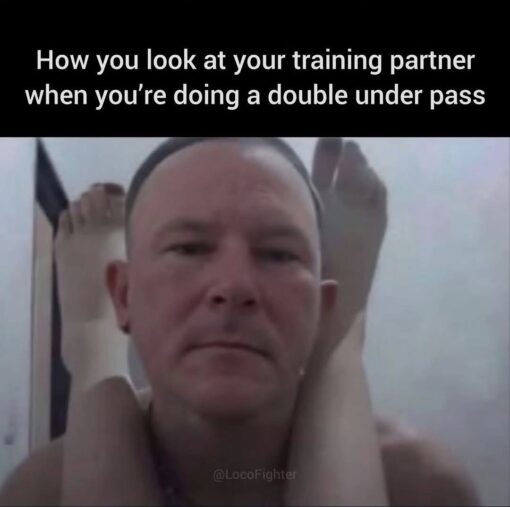 Awkward Memes, BJJ Memes, Fitness Memes, Funniest Memes, Gym Memes, Looks Memes, Martial Arts Memes, MMA Memes, Sports Memes, Workout Memes, A black caption bar at the top reads, “How you look at your training partner when you're doing a double under pass,” followed by the handle “@LocoFighter.” Beneath it, a close-up photo shows a man staring straight ahead with a blank, resigned, almost deadpan expression while another person’s legs are wrapped awkwardly around his neck and shoulders.