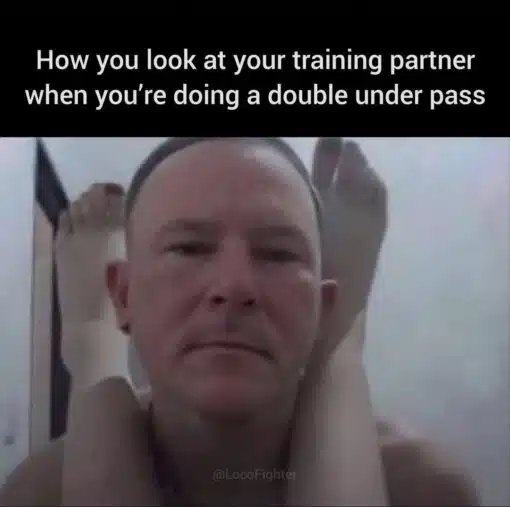 Awkward Memes, BJJ Memes, Fitness Memes, Funniest Memes, Gym Memes, Looks Memes, Martial Arts Memes, MMA Memes, Sports Memes, Workout Memes, A black caption bar at the top reads, “How you look at your training partner when you're doing a double under pass,” followed by the handle “@LocoFighter.” Beneath it, a close-up photo shows a man staring straight ahead with a blank, resigned, almost deadpan expression while another person’s legs are wrapped awkwardly around his neck and shoulders.