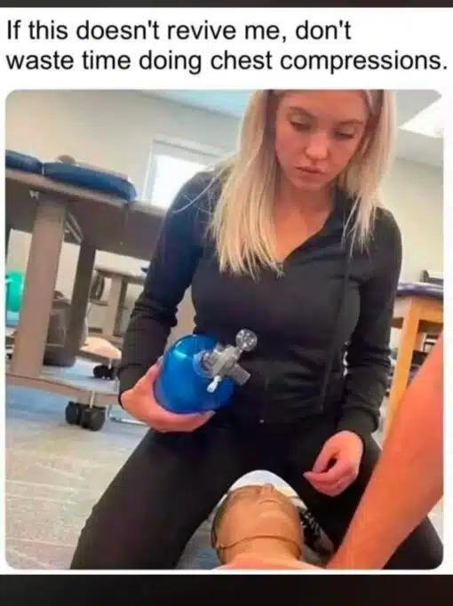Dark Humor, Death Memes, Dirty Mind Memes, Double Meaning Memes, Funniest Memes, Funny Text Memes, Health Memes, Horny Memes, Innuendo Memes, Lindsay Clancy, NSFW, Thirsty Memes, The meme shows a CPR or first-aid training scene, with a blonde woman in a black zip-up top kneeling over a practice mannequin. She is holding a blue resuscitation bag near the mannequin’s face while another person’s arm appears at the edge of the frame, making it look like a medical training demonstration is underway.