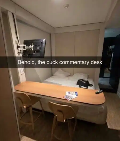 Cheating Memes, Cuck Memes, Dirty Mind Memes, Fetish Memes, Funniest Memes, Furniture Memes, Hotel Memes, Innuendo Memes, NSFW, Relationship Memes, Sex Memes, WTF Memes, The image shows a compact hotel-like room where a long wooden desk is awkwardly positioned directly in front of the bed, with two chairs lined up on the opposite side as if facing a stage. A wall-mounted TV hangs to the left, but the desk-and-chair arrangement makes the bed look like the main attraction.