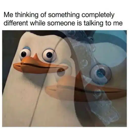 Animal Memes, Awkward Memes, Cartoon Memes, Confused Memes, Conversation Memes, Funniest Memes, Mood Memes, Movie Memes, Psychology Memes, The meme shows a close-up of Skipper, the penguin from the animated Madagascar franchise, staring ahead with wide, blank eyes. Overlaid behind him is a faded, ghostlike second image of the same penguin underwater with bubbles, making it look like his mind has drifted far away from the present moment. The caption at the top reads, “Me thinking of something completely different while someone is talking to me,” framing the image as a visual metaphor for zoning out during a conversation.