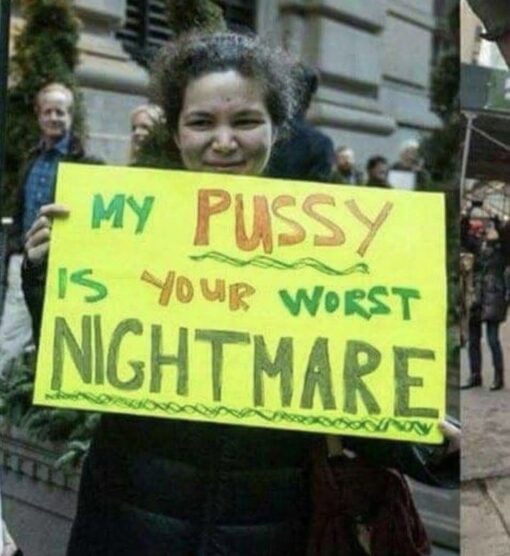 Dirty Mind Memes, Dirty Text Memes, Double Meaning Memes, Feminist Memes, Funniest Memes, Funny Sign Memes, Innuendo Memes, NSFW, Offensive Memes, Protestor Memes, Scary, Sex Memes, Vagina Memes, A smiling woman stands outdoors on a city sidewalk holding a large neon-yellow handmade poster. The sign is written in bold green and orange marker, with oversized words arranged for maximum impact: “MY PUSSY IS YOUR WORST NIGHTMARE.” The image has the look of a candid protest or street-demonstration photo: casual clothing, people in the background, and a homemade placard that feels intentionally confrontational, funny, and attention-grabbing.