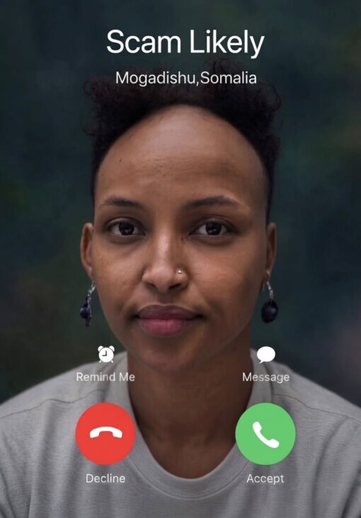 Deception Memes, Funniest Memes, Funny Text Memes, Phone Memes, Scam Memes, Tech Memes, Trust Issues Memes, WTF Memes, The image is styled like an incoming smartphone call screen, with the name “Scam Likely” displayed prominently at the top and “Mogadishu, Somalia” underneath as the supposed caller location. Over a close-up portrait of a calm, expressionless woman, the familiar iPhone-style options appear: “Remind Me,” “Message,” a red “Decline” button, and a green “Accept” button. The soft portrait background contrasts with the blunt phone-interface warning, making the scene look like a real incoming call from someone your phone has already decided is suspicious.