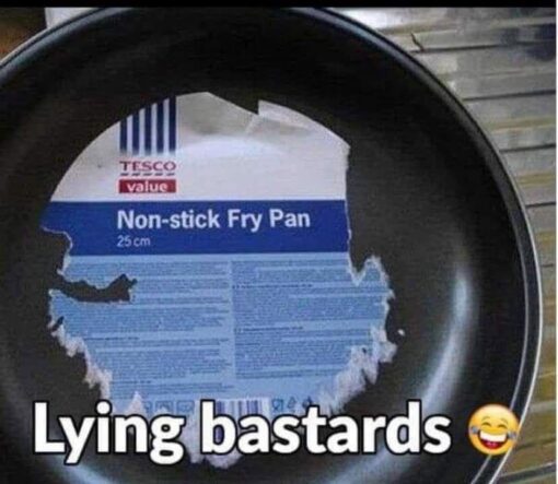 Cooking Memes, Deception Memes, Expectation vs Reality, Food Memes, Frustrated Memes, Funniest Memes, Grocery Memes, Ironic Memes, Liar Memes, Shopping Memes, A close-up photo shows a black Tesco Value frying pan with a large paper product label stuck firmly to the inside cooking surface. The label says “Non-stick Fry Pan” and “25 cm,” but instead of peeling away cleanly, it has torn into ragged pieces and left a stubborn layer of paper stuck to the pan.