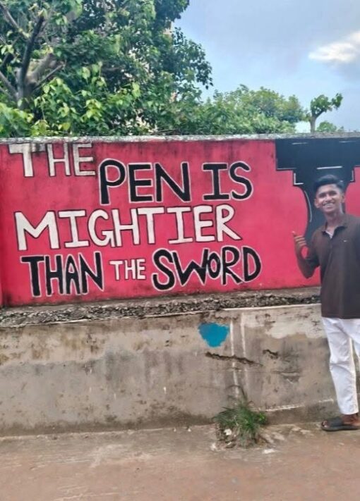 Adage Memes, Art Memes, Funniest Memes, Funny Sign Memes, Quote Memes, Wise Sayings Memes, Writer Memes, A bright red wall is painted with the phrase “THE PEN IS MIGHTIER THAN THE SWORD” in large, bold, hand-drawn letters. The words are arranged unevenly across the wall, with “PEN” and “SWORD” emphasized in bigger, darker lettering, giving it the look of a public mural or school-style inspirational slogan.