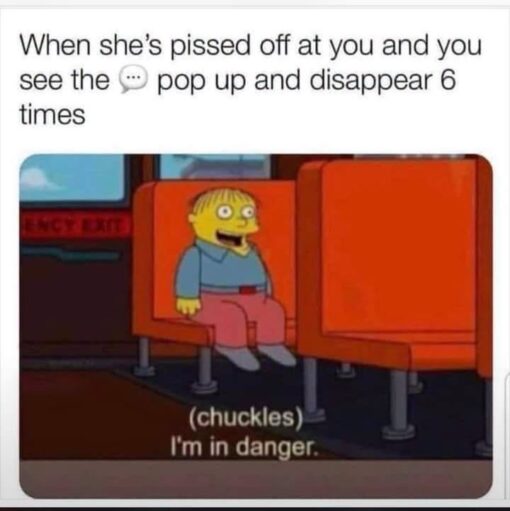 Angry Text Memes, Anxiety Memes, Cartoon Memes, Couple Memes, Dating Memes, Funniest Memes, Funny Text Memes, Girlfriend Memes, Messenger Memes, Phone Memes, Pop Culture Memes, Relationship Memes, Simpsons Memes, The meme shows a screenshot from The Simpsons featuring Ralph Wiggum sitting alone in an orange booth, wearing his usual blank, wide-eyed expression. Above the image is a caption about watching a message typing bubble appear and vanish repeatedly when someone is angry with you. At the bottom of the cartoon frame, Ralph’s subtitle reads, “(chuckles) I’m in danger,” turning his nervous little smile into the punchline for an impending digital argument.
